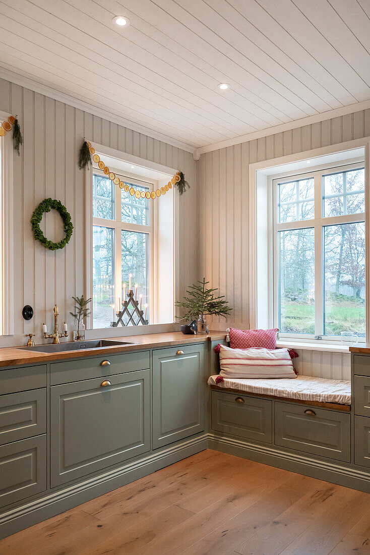 Seating window with cushions in a green country-style kitchen