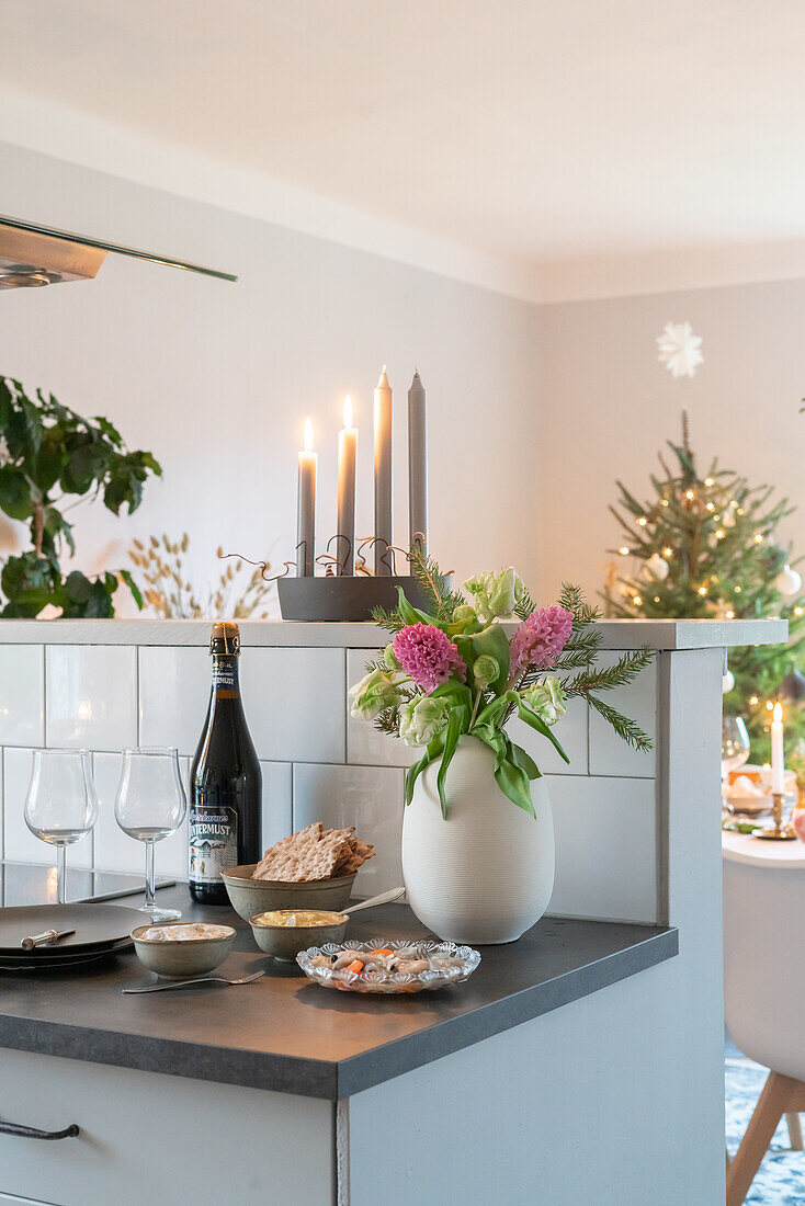 Christmas-themed counter with candles and flower vase in the kitchen