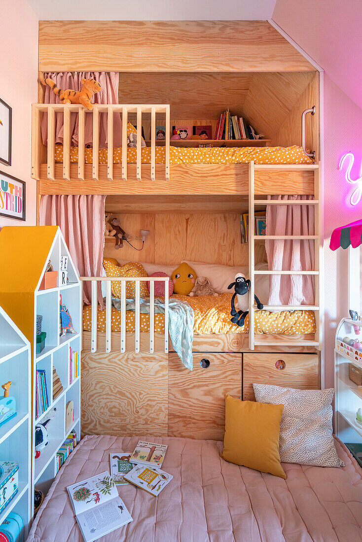 Bunk bed, house-shaped shelves, cushions and books in children's room