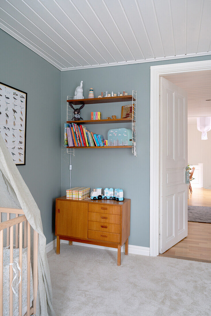 Retro chest of drawers and retro shelf, grey carpet and walls in light blue