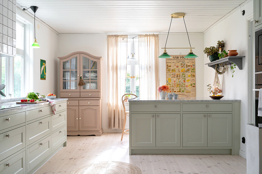 Country kitchen with green cupboards and vintage decorations