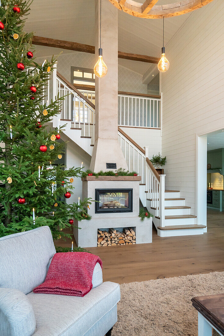 Living room decorated for Christmas with fireplace and fir tree