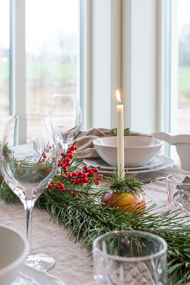 Festive dining table with candles and fir branches