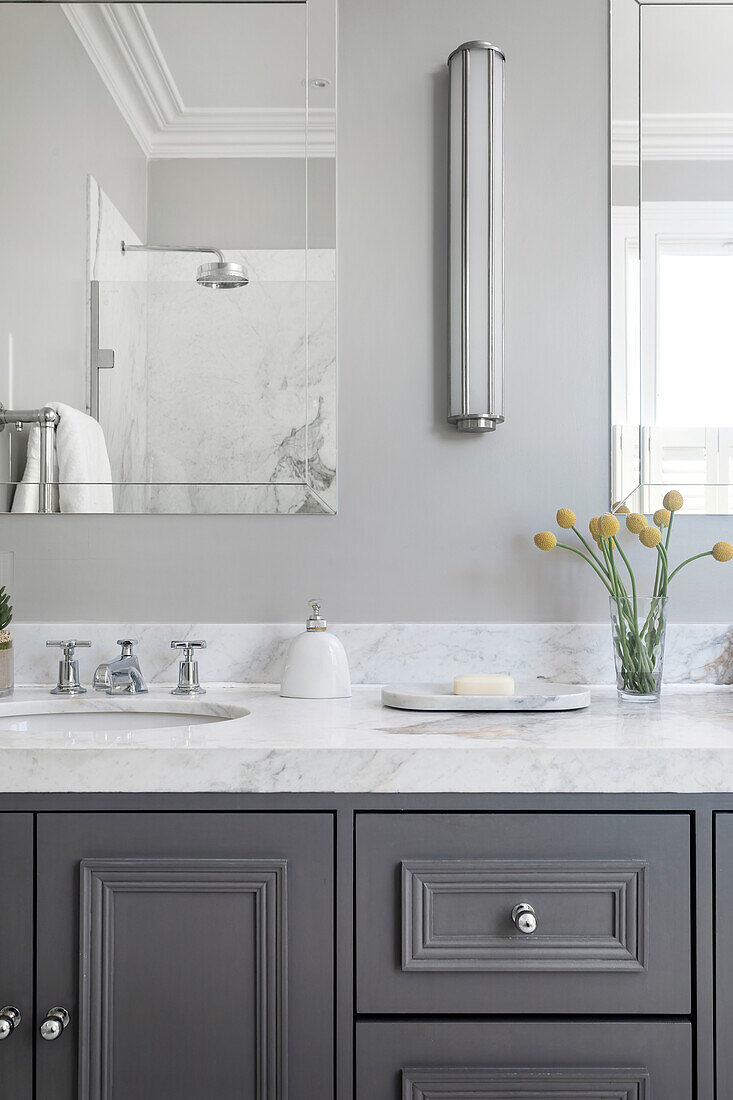 Grey sink cabinet with marble top in the bathroom