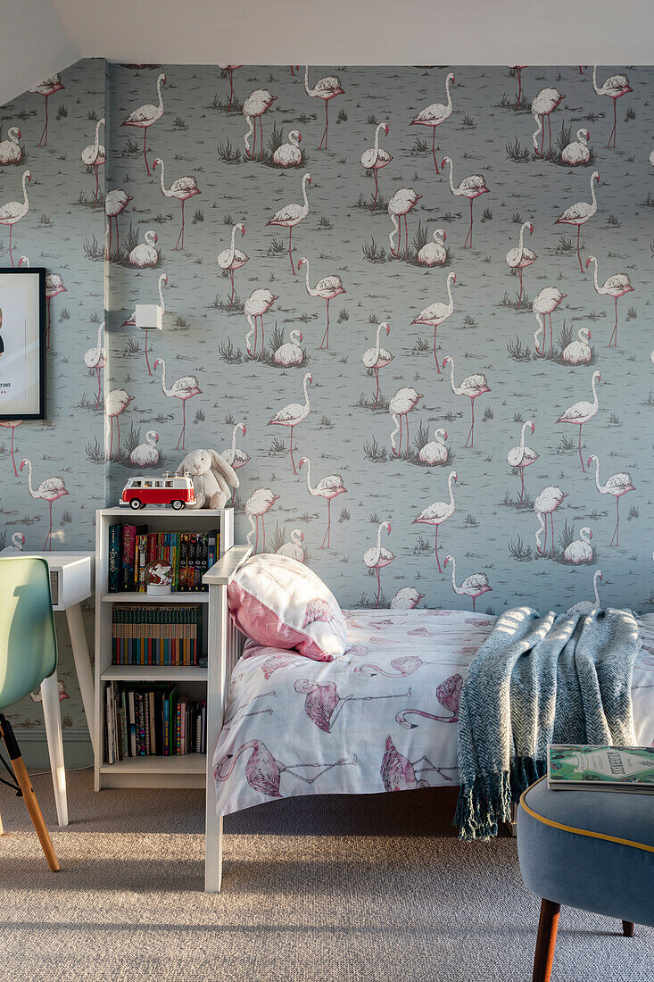 Bed and shelf in the children's room, wallpaper with flamingo motif
