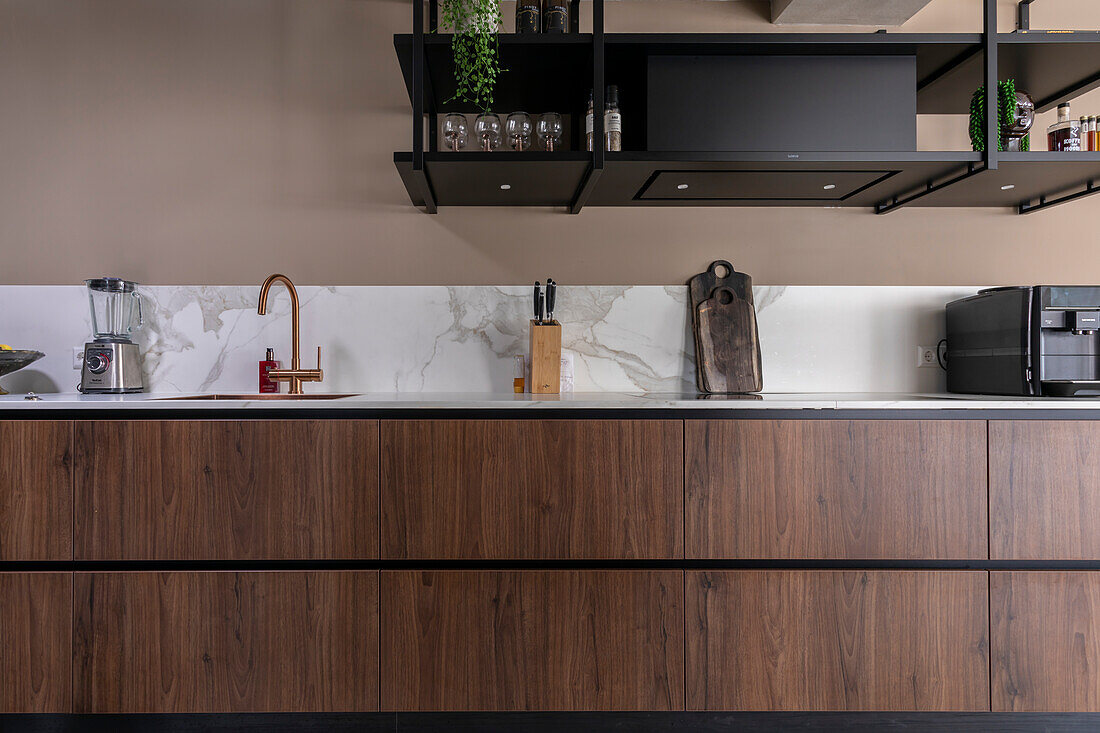 Modern kitchen unit with marble splashback and dark wooden cupboards