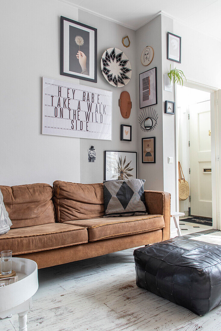 Living room with brown leather sofa and wall decoration