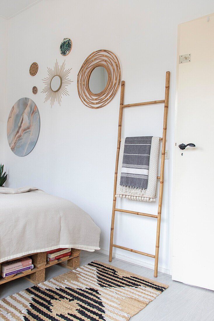 Light-coloured bedroom with wall decoration and bamboo ladder