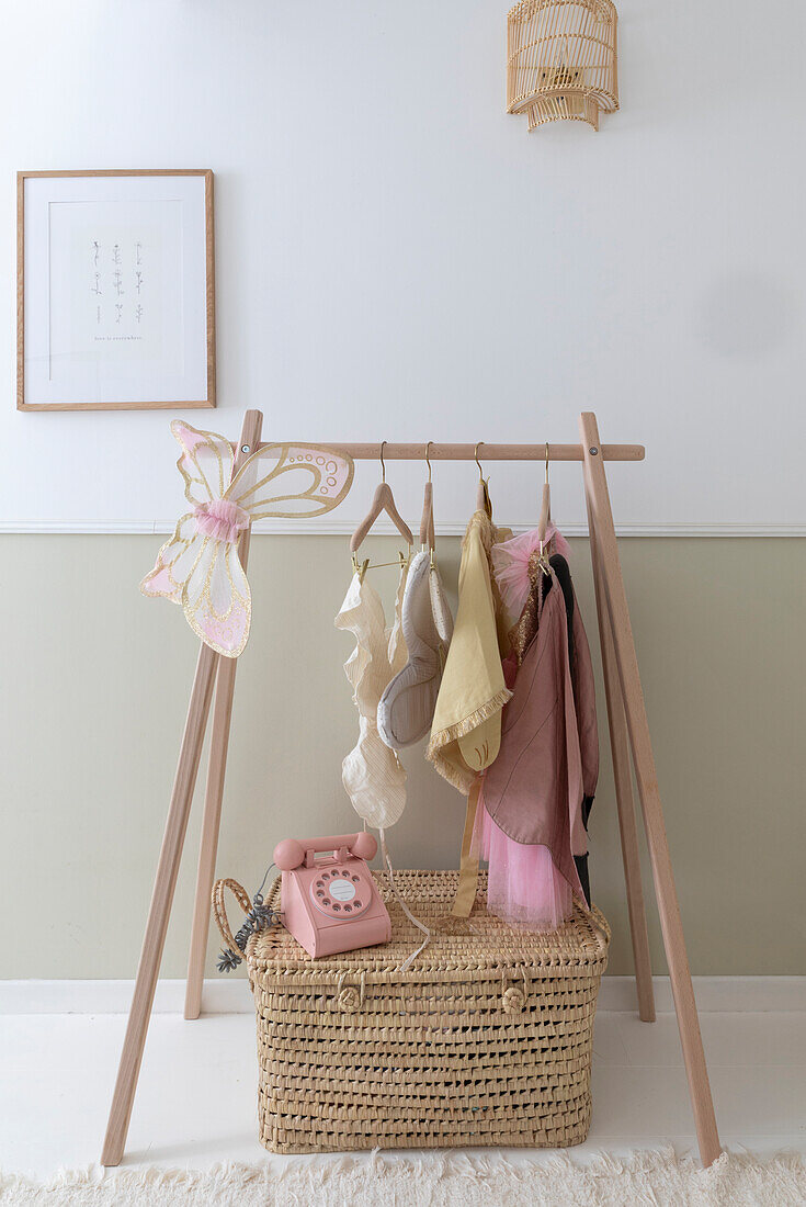 Wooden coat rack and pink telephone on woven basket