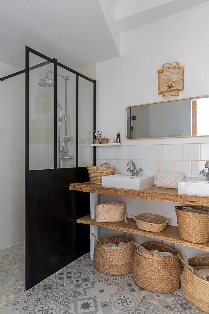 Bathroom with shower cubicle, storage baskets and patterned tiled floor