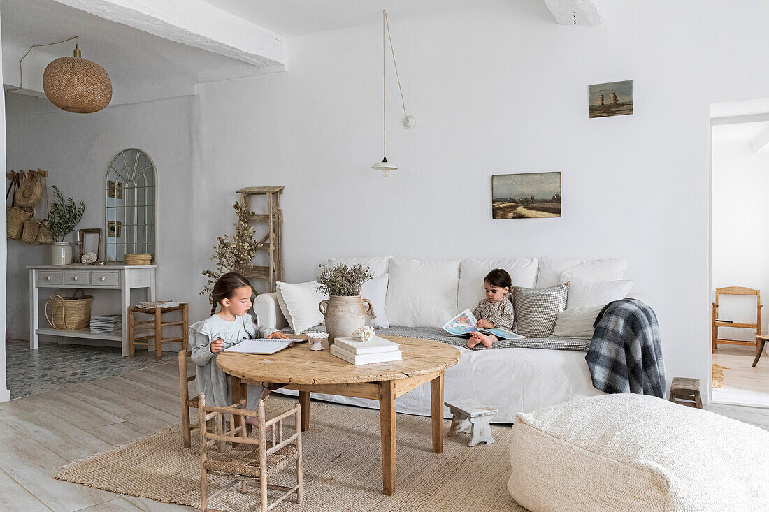 Helles Wohnzimmer mit zwei Kindern, die Bücher anschauen