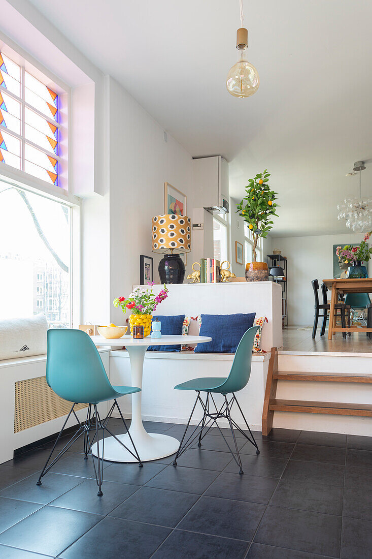 Dining area with window seat, colourful cushions and stained glass windows