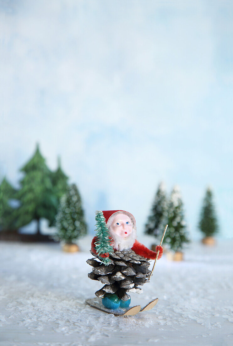 DIY gnome made from pine cones on skis in artificial snow