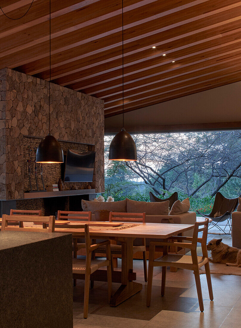 Dining area with pendant lights in an open living room at dusk