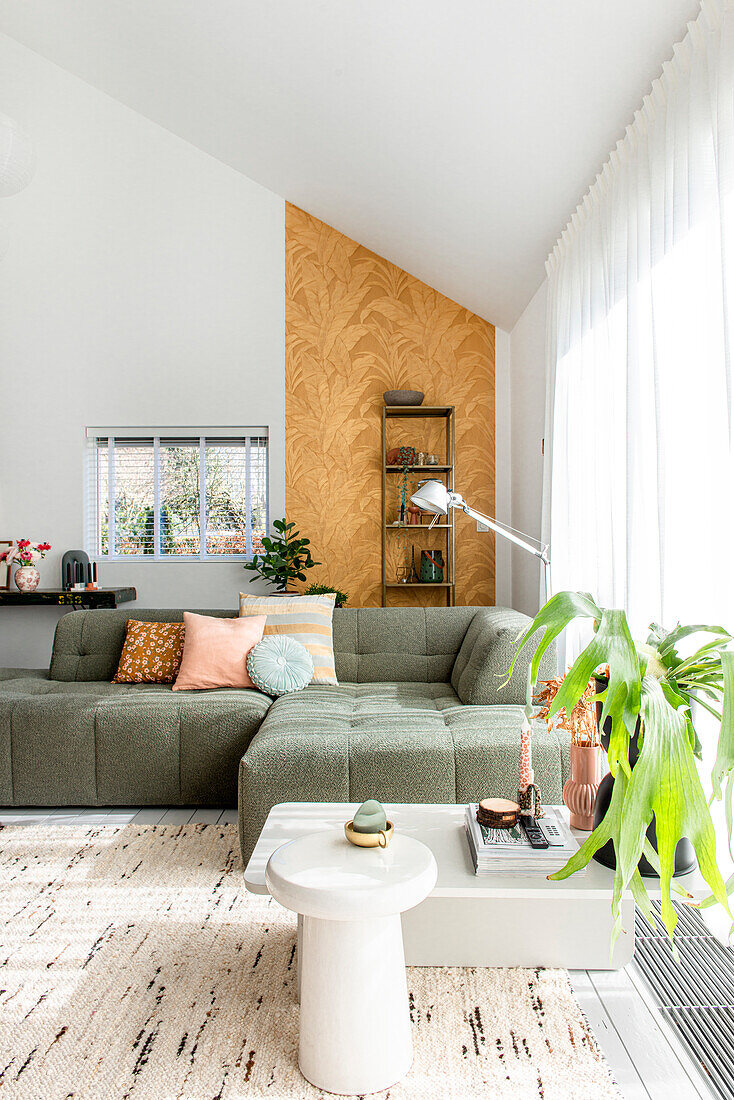 Modernes Wohnzimmer mit grüner Couch, gemustertem Teppich und Akzentwand in Holzoptik