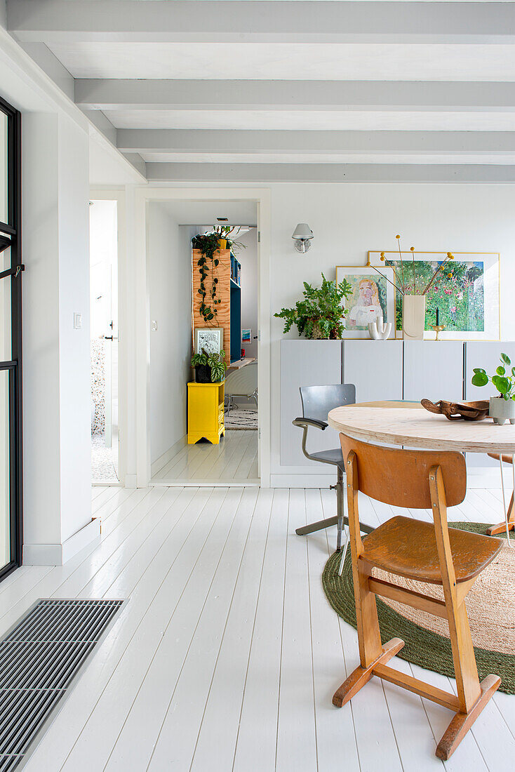 Helles Esszimmer mit weißem Boden und skandinavischem Design, Blick in den Flur