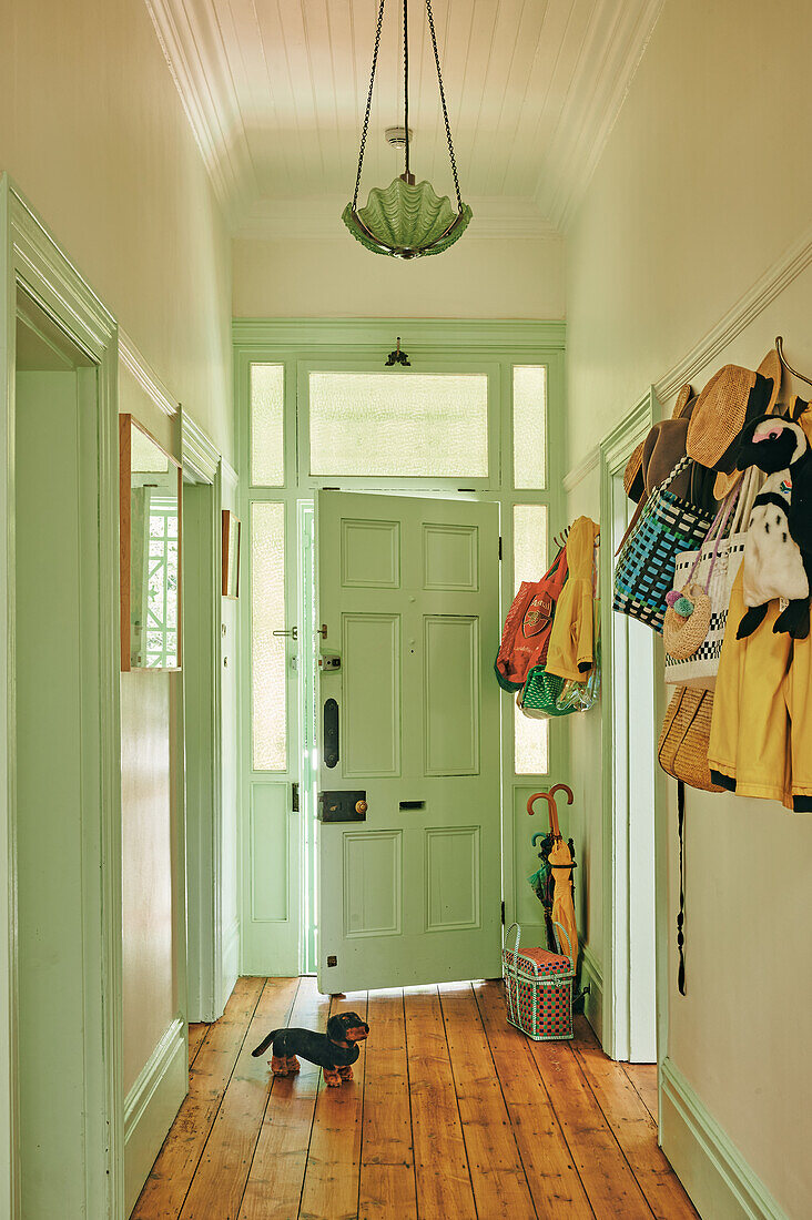 Hallway with wooden floor, green doors and wall-mounted wardrobe