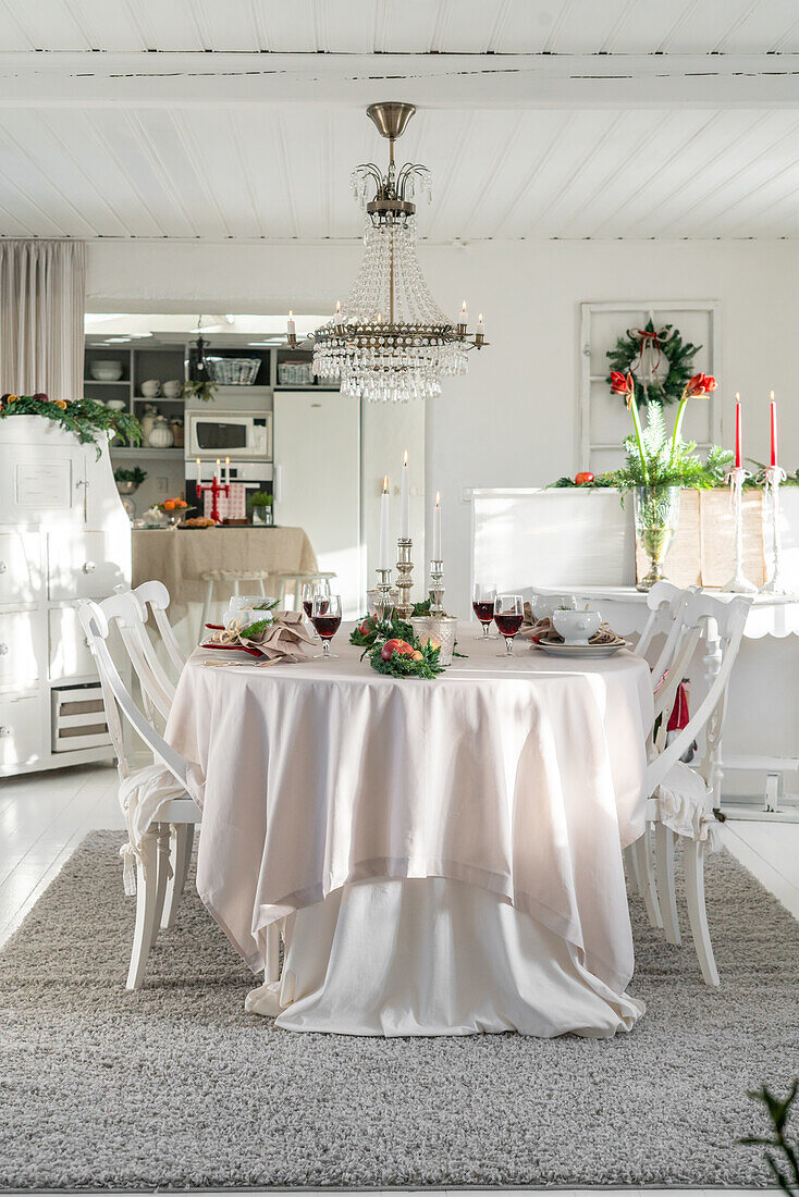 Festively set dining table with chandelier for Christmas