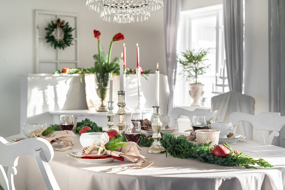 Festive dining table with candles and Christmas greenery