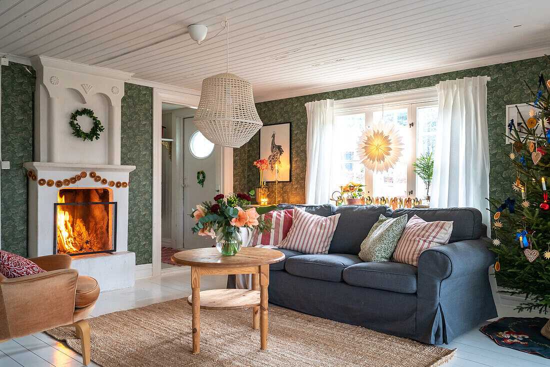 Living room with fire in fireplace and Christmas tree, decorated in Scandinavian style