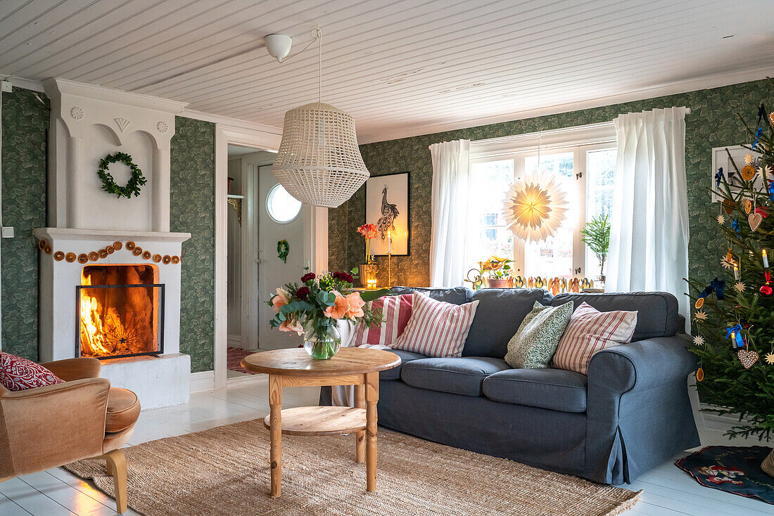 Wohnzimmer mit Kaminfeuer und Weihnachtsbaum, im skandinavischen Stil dekoriert