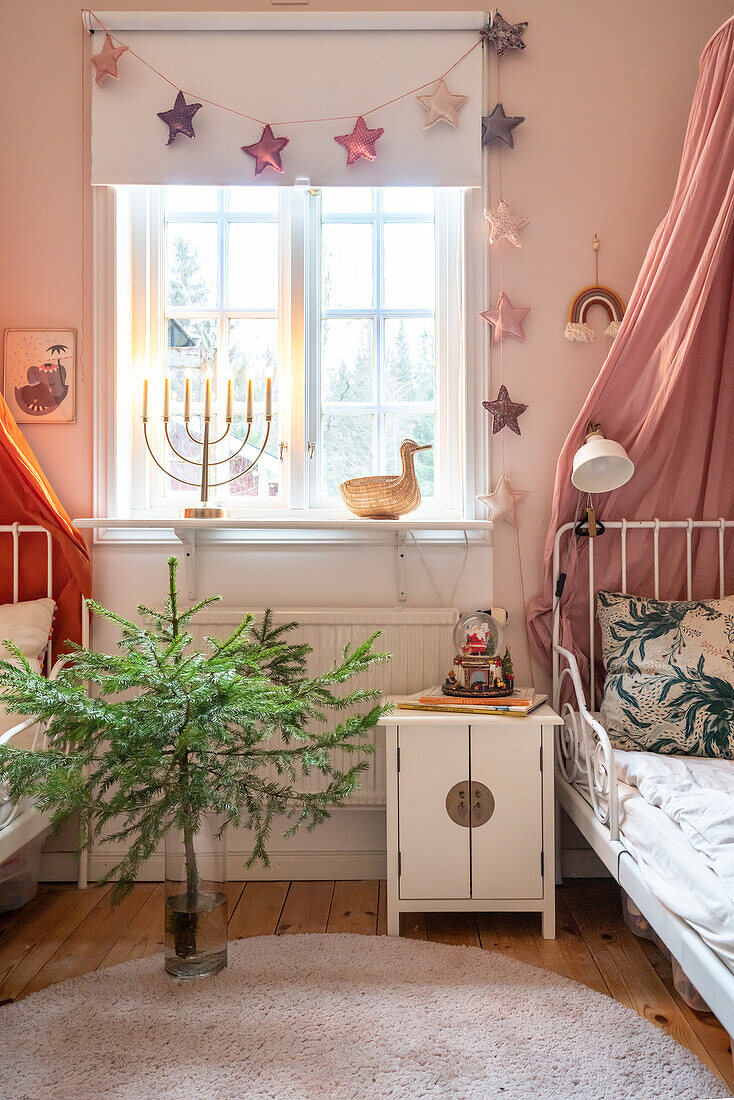 Kinderzimmer mit Weihnachtsdeko, Tannenbaum und Menora im Fenster