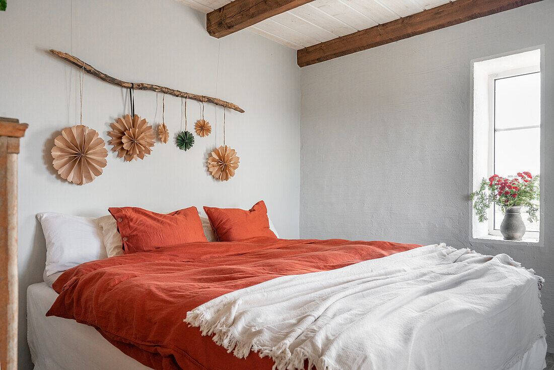 Bedroom with wall decoration and bouquet of flowers on the windowsill