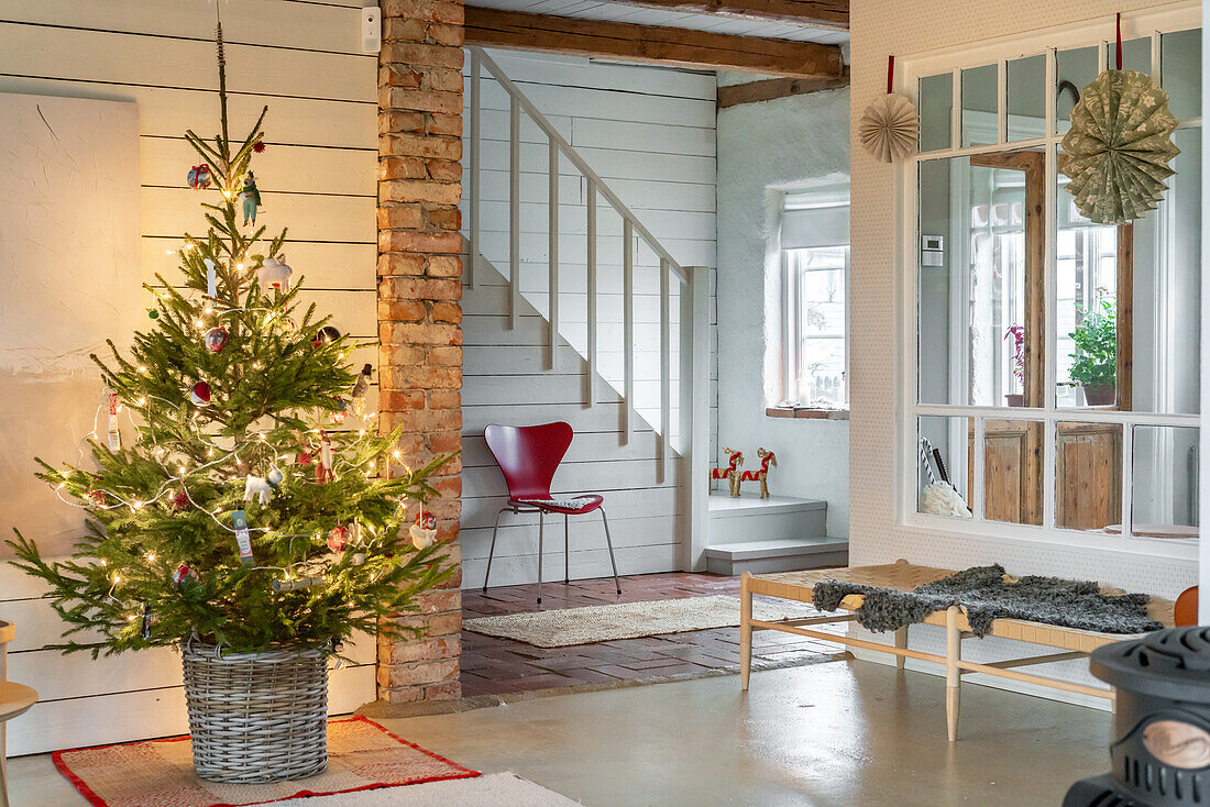 Christmas tree in a basket in the living room with wooden and brick elements