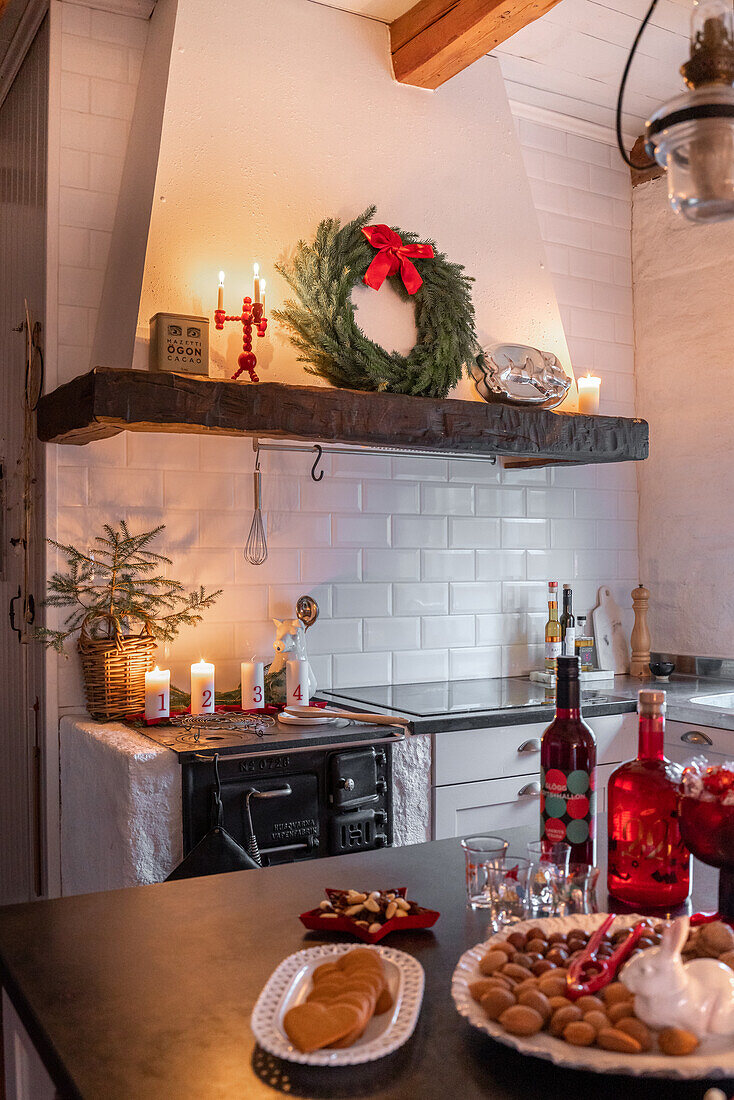 Kitchen decorated for Christmas with candles and a fir wreath above the cooker