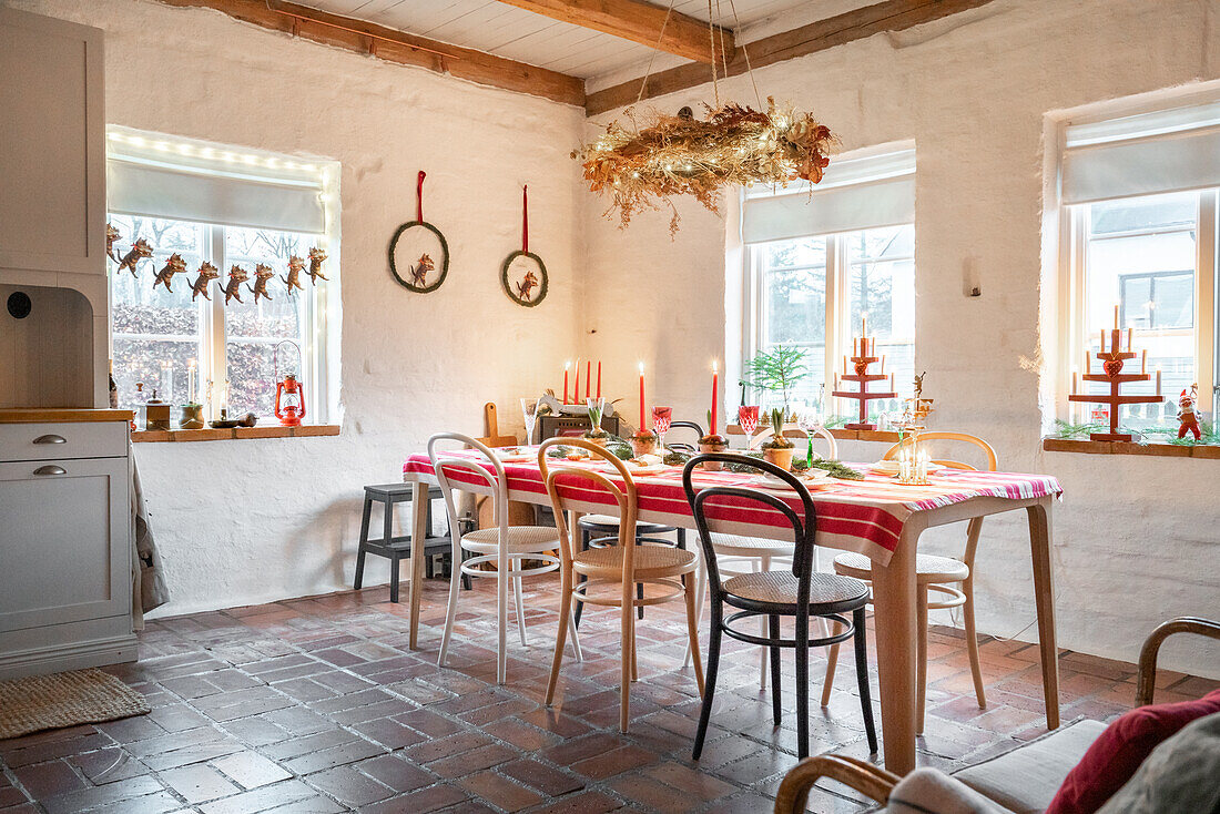 Christmas dining table with candles and branches in a rustic room