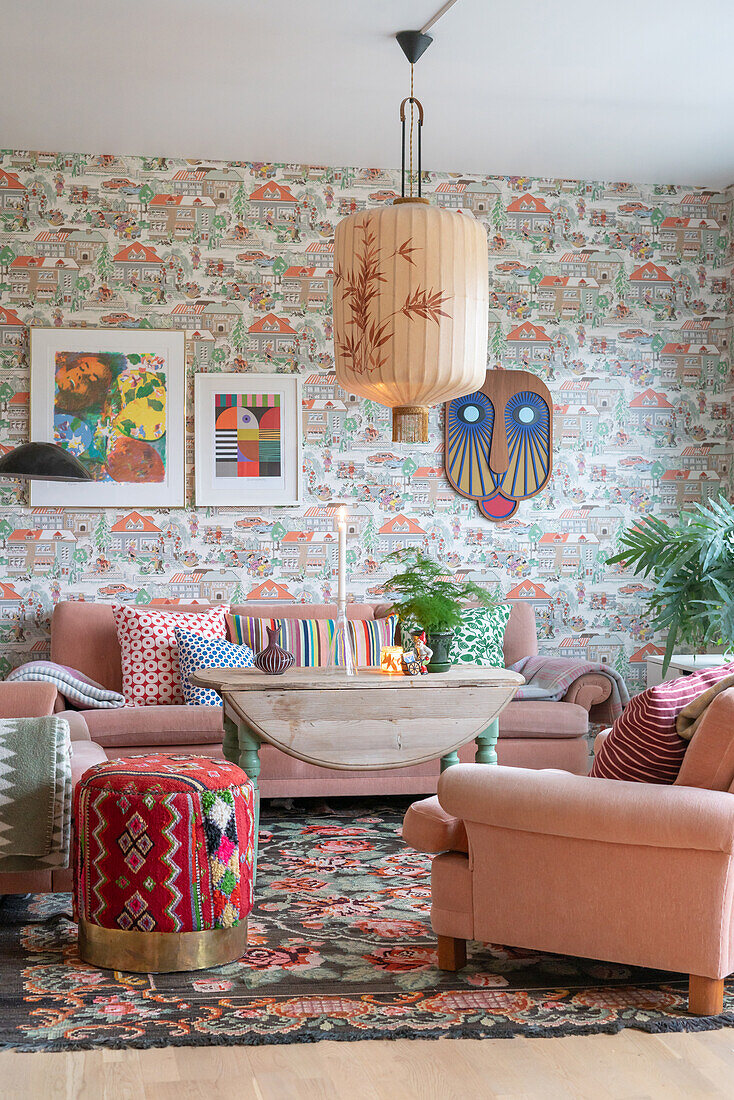 Wohnzimmer mit rosa Polstergarnitur und Vintage Tapete