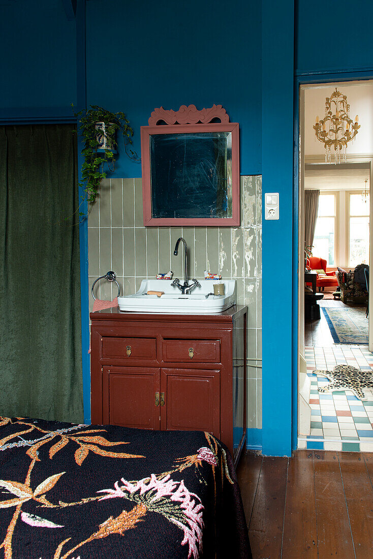 Vintage wooden vanity unit in bedroom with blue wall