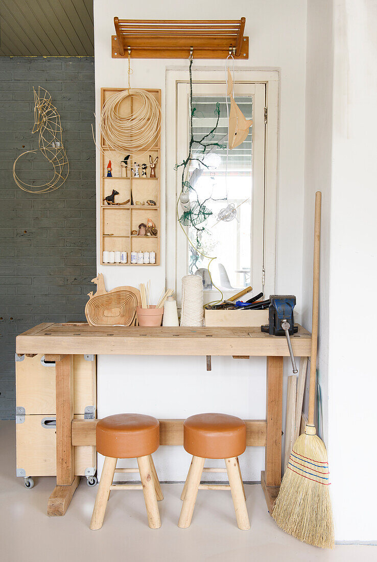 Workbench made of light-colored wood with leather stools