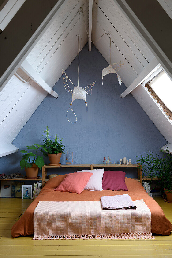Futon bed in the attic room with blue wall