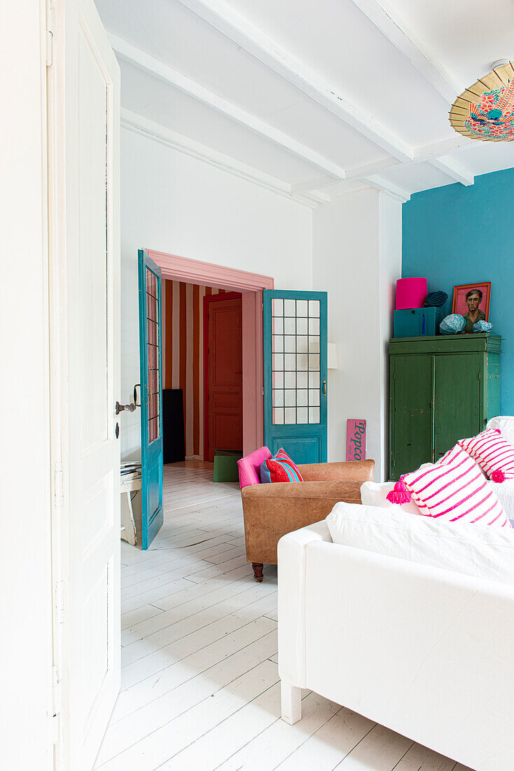 Bright living room with colorful furnishings and white floorboards