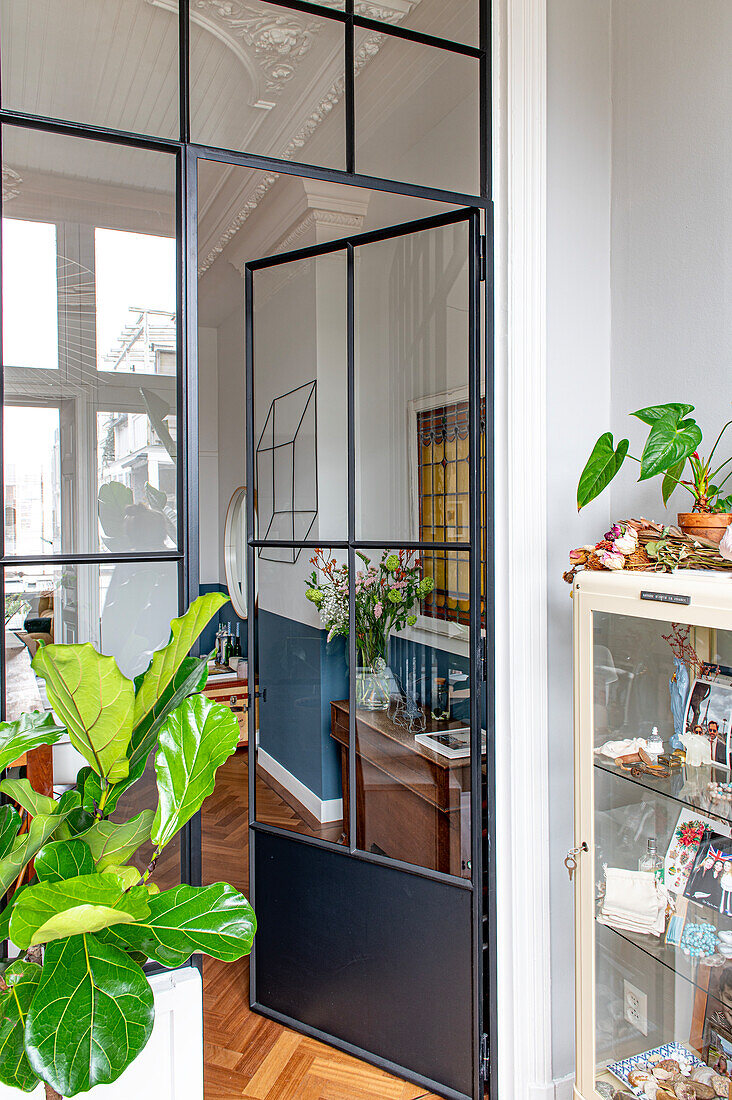 Stilvolles Interieur im Altbau mit Glastür und Zimmerpflanze