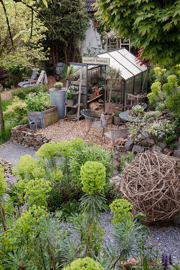 Vielseitig bepflanzter Garten mit Gewächshaus