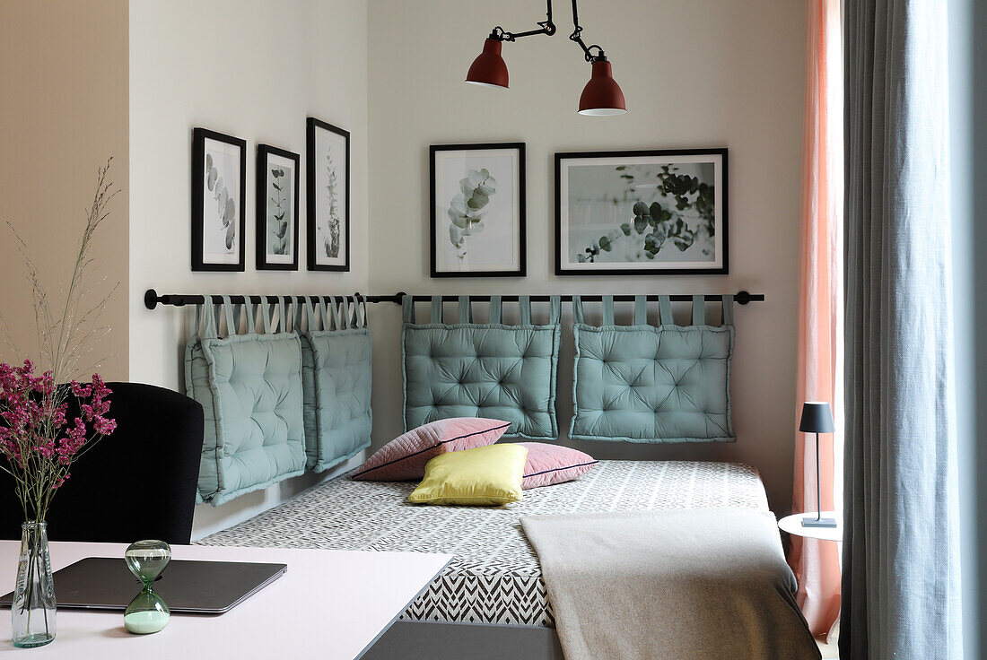 Upholstered bed with decorative cushions and murals in the bedroom