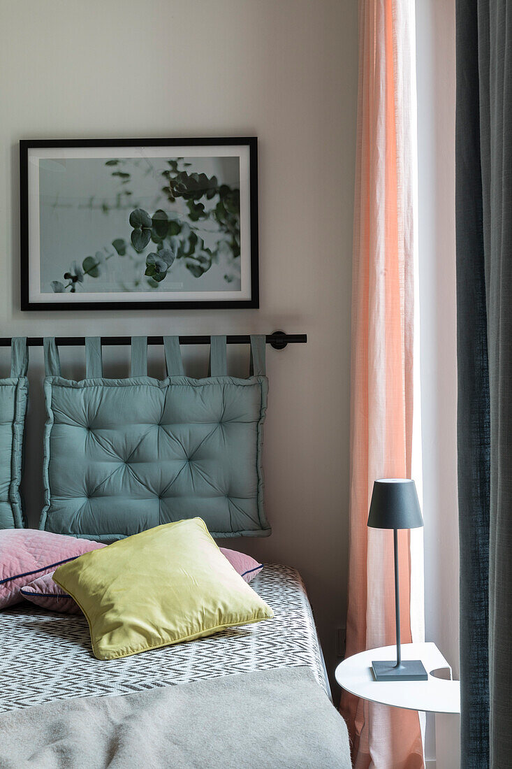 Upholstered headboard and graphic bed linen design in a modern bedroom