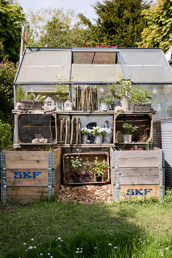 Upcycling garden shelf made from an old wooden crate, greenhouse in the background
