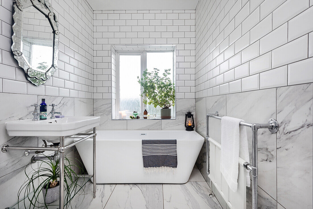 Badezimmer mit freistehender Badewanne und Metrofliesen an der Wand