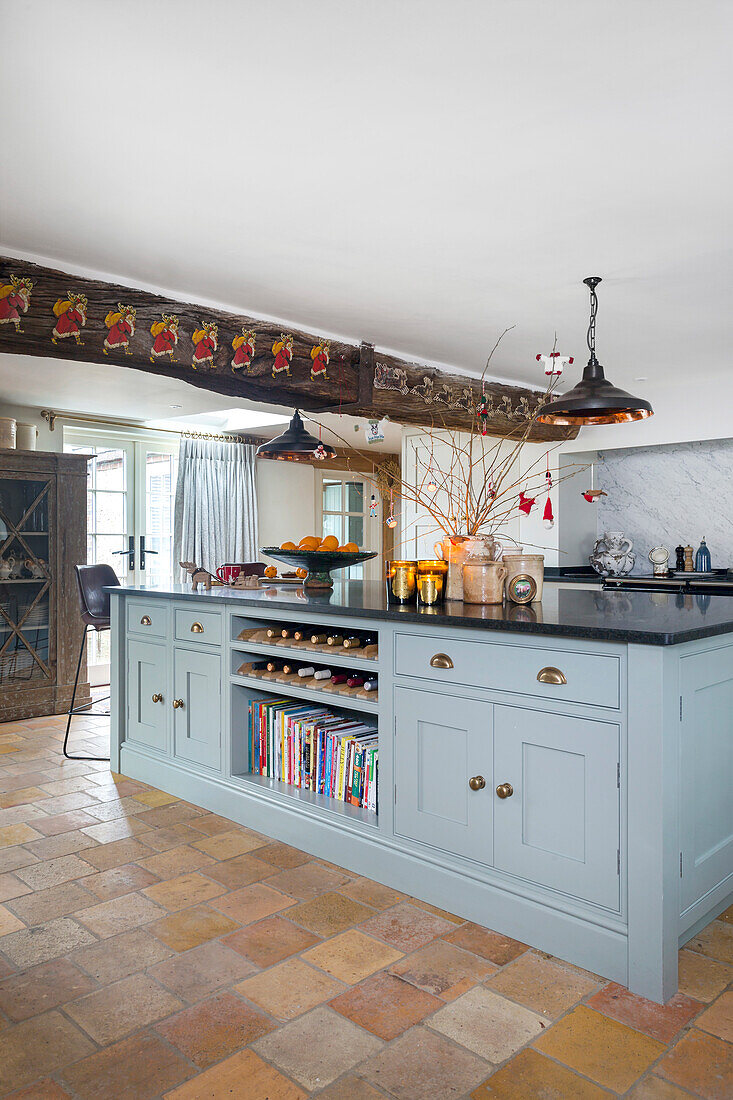 Country kitchen with blue base units, terracotta tiles and Christmas garland