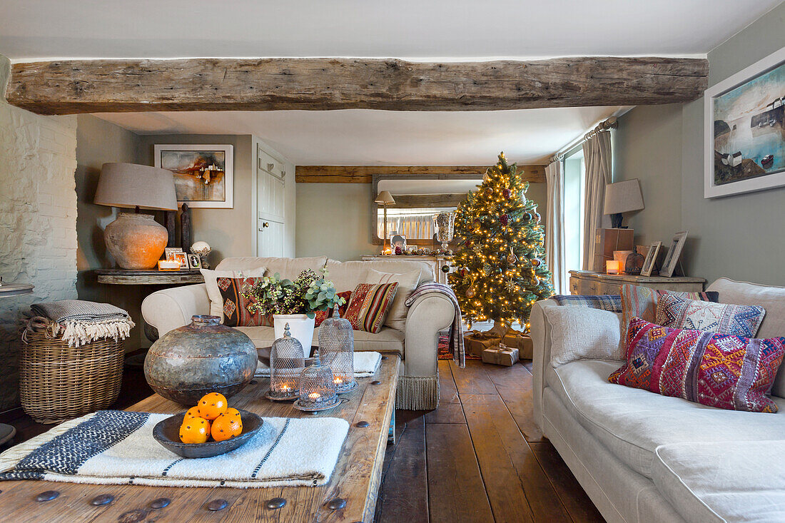 Rustic living room with wooden beams and a Christmas tree in the background