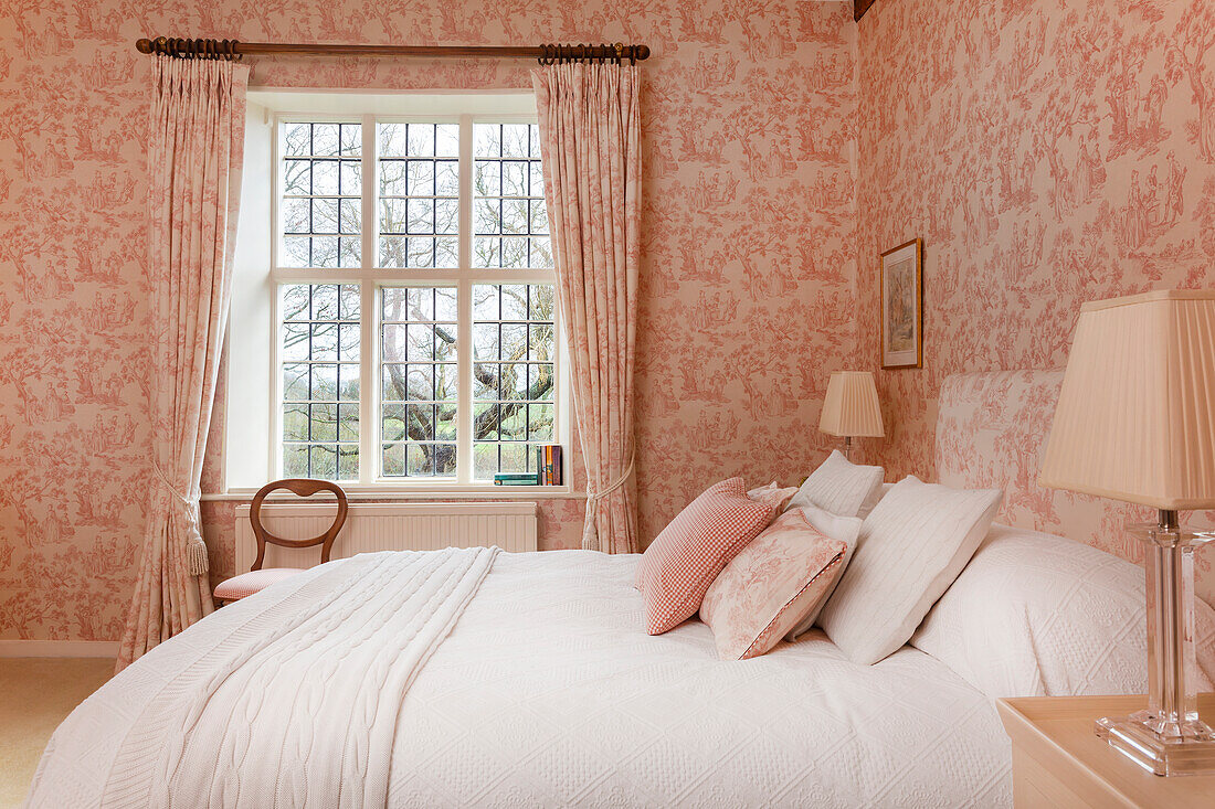 Bedroom with pink floral pattern wallpaper and garden view