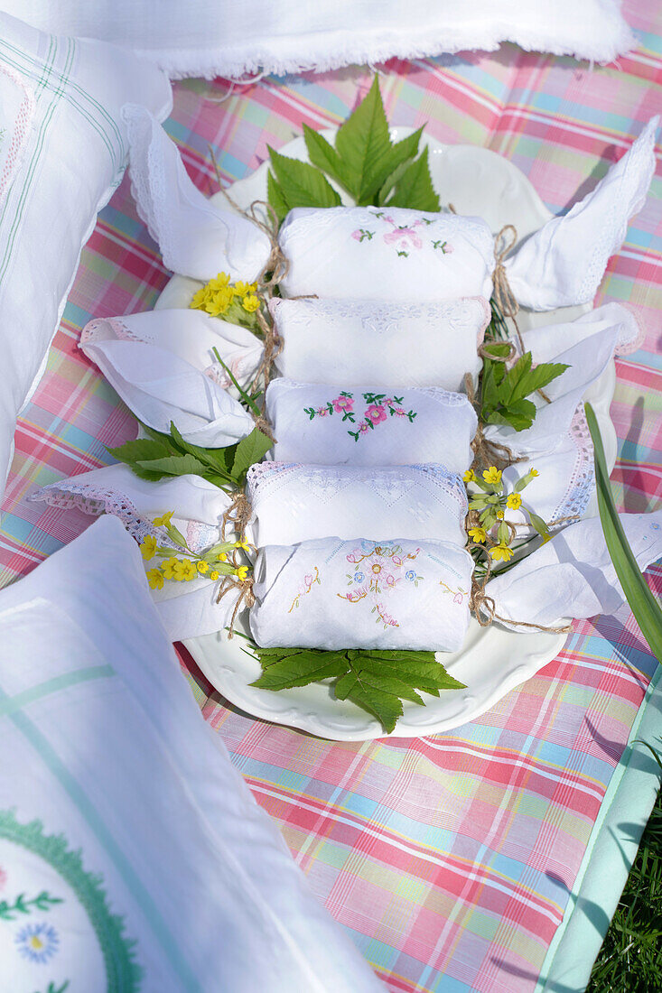 Bestickte Servietten mit Frühlingsblumen auf einer Picknickdecke