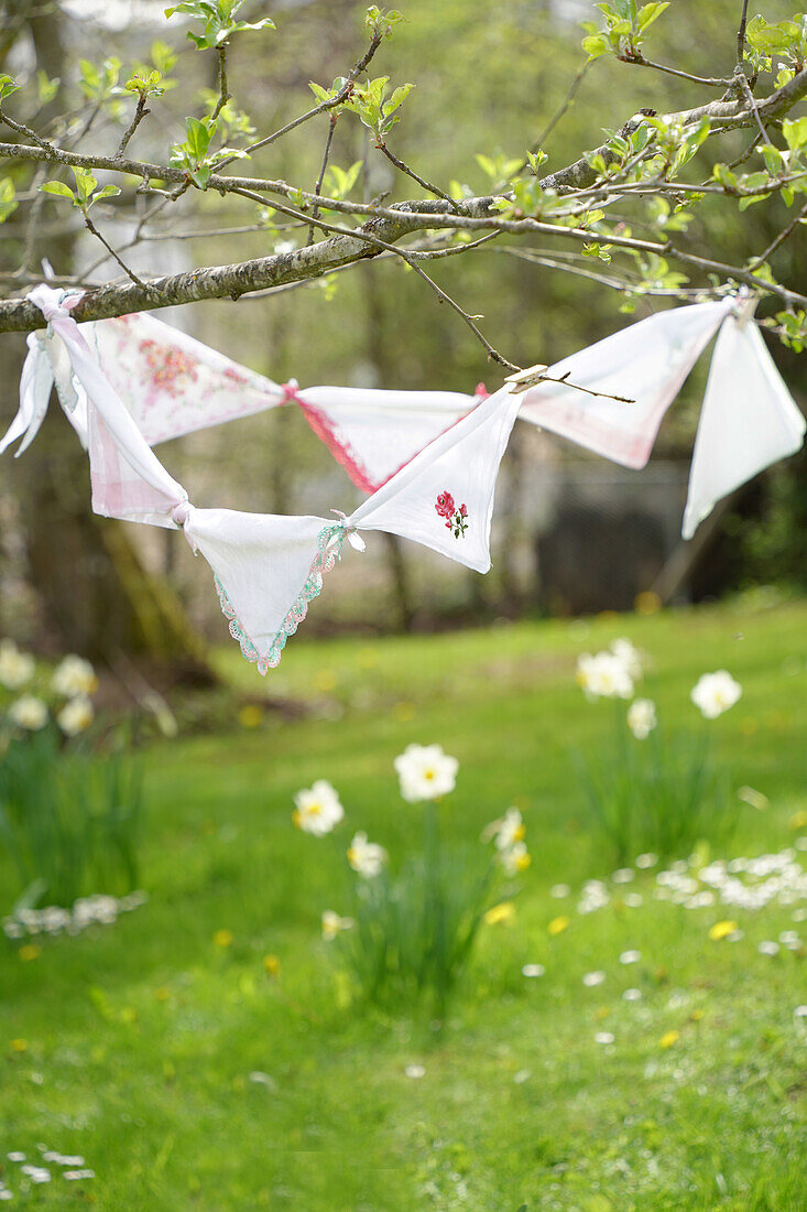 Handmade pennant chain in the spring garden with daffodils