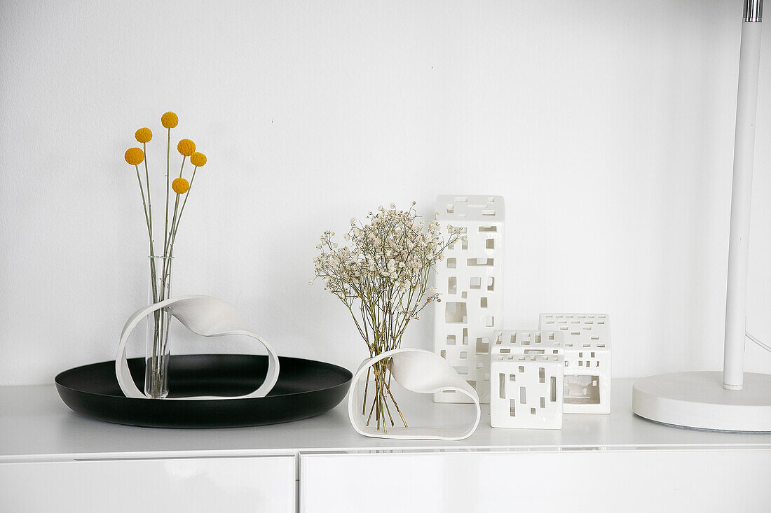 Minimalist decoration with homemade vases and dried flowers on a white shelf