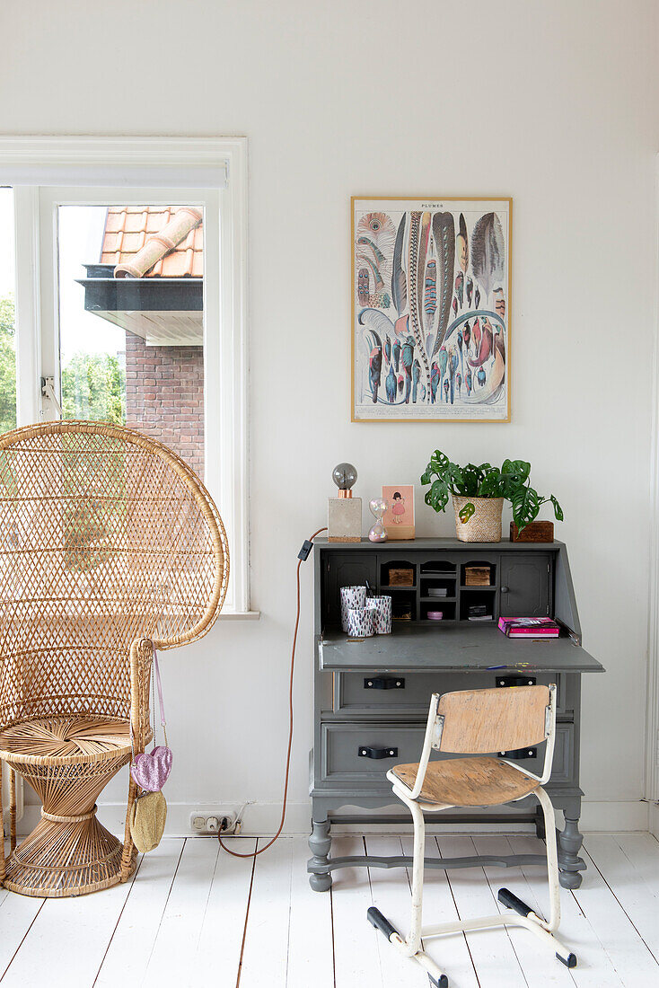 Bright study with plants, rattan armchair and vintage desk