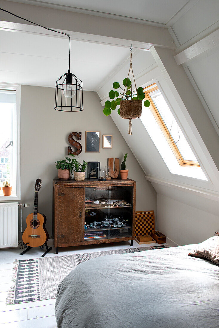 Attic bedroom with vintage furniture and plants