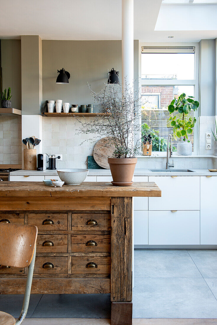 Heller und moderner Küchenbereich mit rustikalem Küchenblock und grünen Pflanzenakzenten